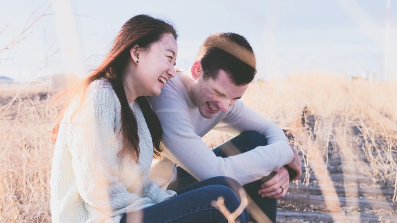 A couple sitting outside laughing