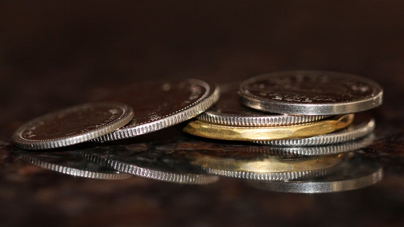 Six coins stacked on a reflective surface