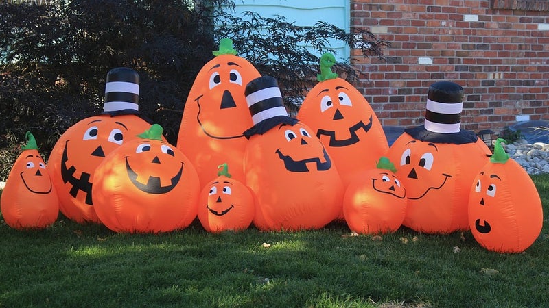 Pumpkin balloons with faces on a lawn