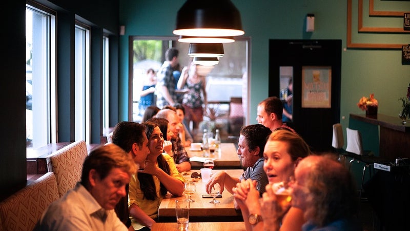 People sitting at tables in a dimly lit restaurant