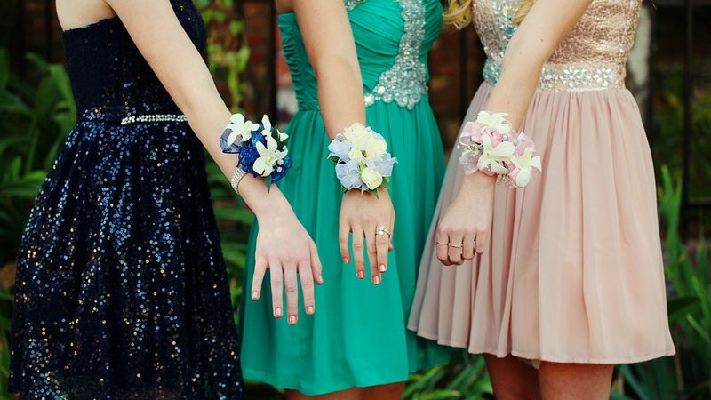 Three girls in dresses with wrist corsages