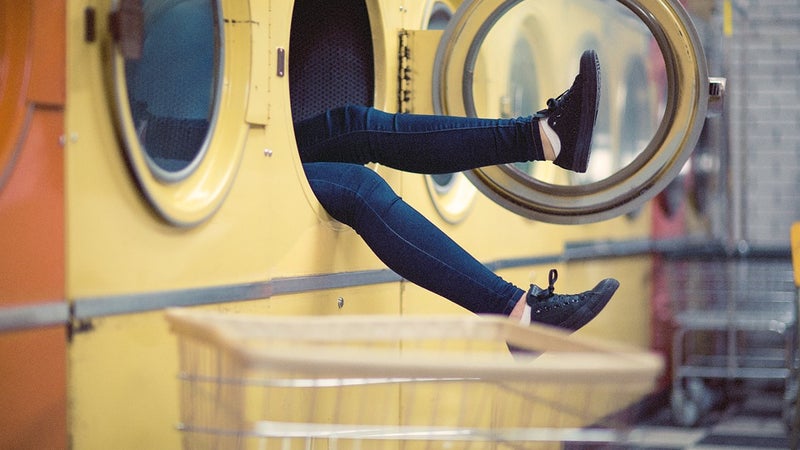 Two legs sticking out of an industrial sized dryer