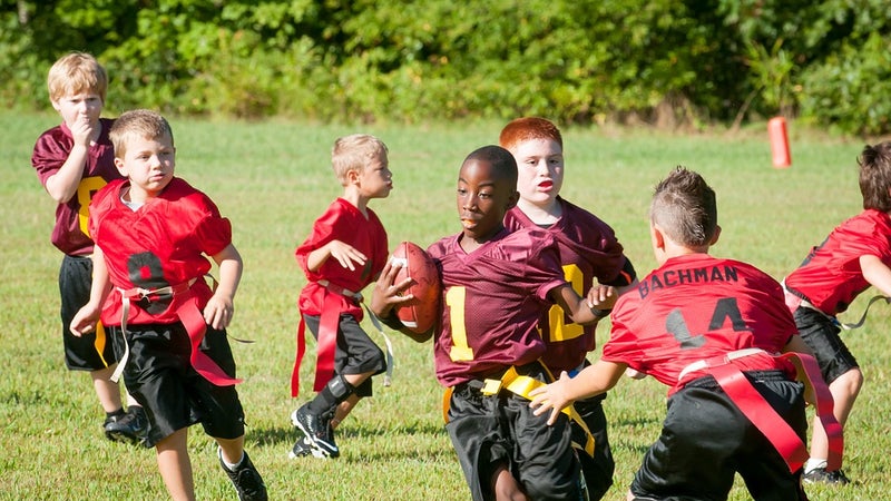 A group of children playing flag football