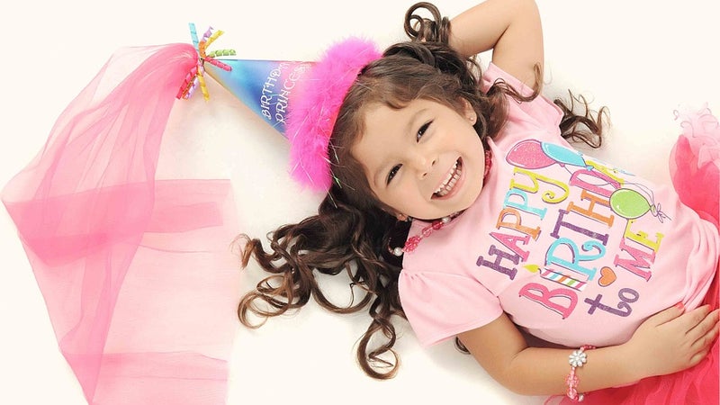 Young girl with a birthday hat and shirt on
